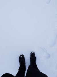 Low section of person standing on snow