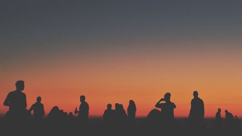 Silhouette people standing against clear sky during sunset