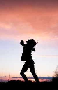 Silhouette of kif runing on field against sky during sunset