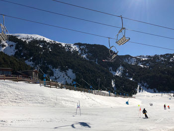 People walking on snow covered mountain against sky