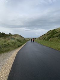 Rear view of man on road against sky