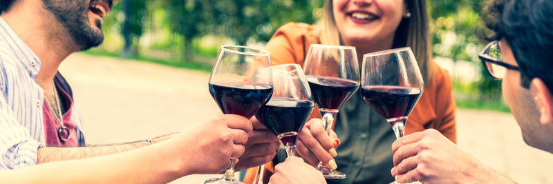 Midsection of woman holding wineglass