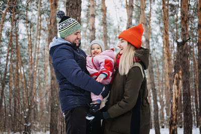 Outdoor family activities for happy winter holidays. happy father and mother playing with little