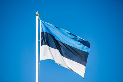 Low angle view of flag against blue sky