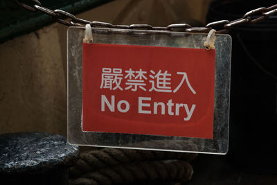 Close-up of no entry sign hanging outdoors