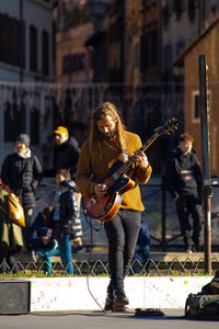 People playing guitar on street in city