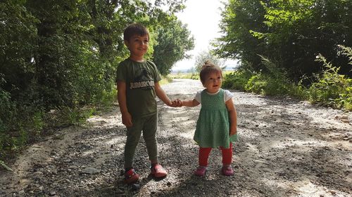 Full length portrait of happy girl standing on tree