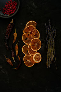 High angle view of dried orange fruits and herbarium on table