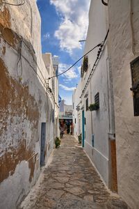 Narrow alley amidst buildings against sky