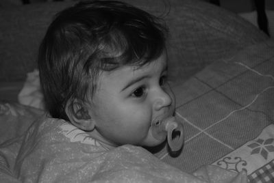 Close-up of cute baby boy sucking pacifier at home