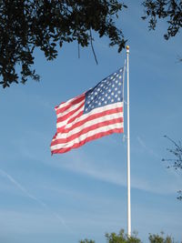 Low angle view of flag against blue sky