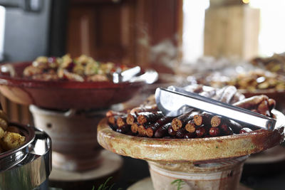 Cooked belgian food placed in ceramic containers with a fire underneath to keep it warm.