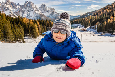 Full length of smiling boy on snow covered mountain