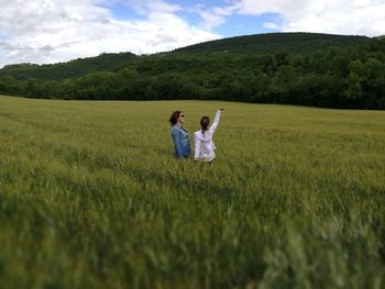 Scenic view of grassy field against cloudy sky