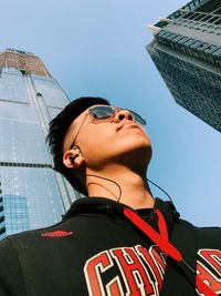 Low angle view of woman looking away against building