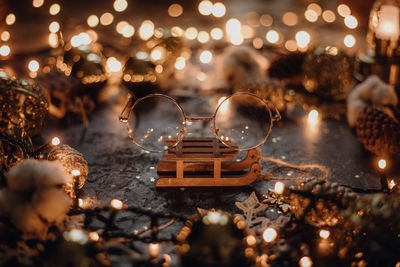 Close-up of illuminated christmas lights on glass table