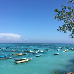 Boats in calm blue sea against sky