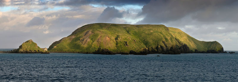 Panoramic view of sea and mountains against sky