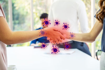 Midsection of people holding purple flowering plant