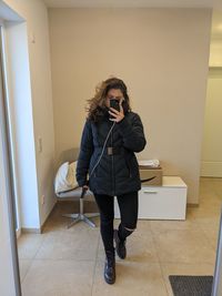 Full length portrait of young woman standing on floor at home