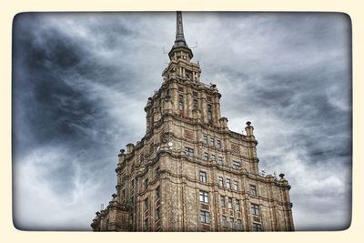 Low angle view of tower against cloudy sky