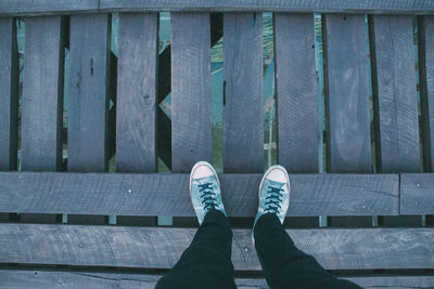 Low section of man standing on footbridge