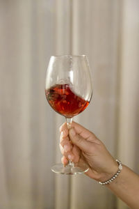 Midsection of person holding wineglass