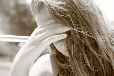 Close-up of tensed teenage girl with head in hand