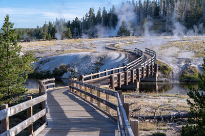 Panoramic shot of footbridge over lake against trees