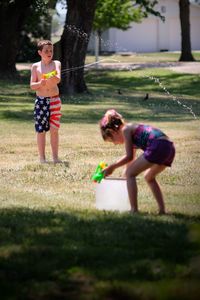 Full length of siblings playing on grass