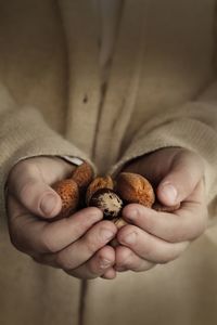 Midsection of woman holding almonds