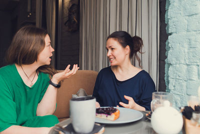 Two women talking and drinking coffee in cafe