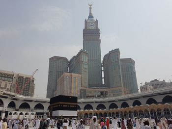 Group of people in front of buildings against sky