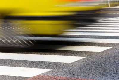 Blurred motion of taxi on zebra crossing in city
