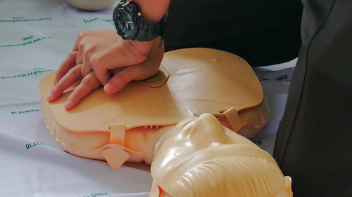 Cropped image of paramedic practicing cpr on mannequin