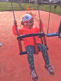 Low angle view of girl playing on swing at playground