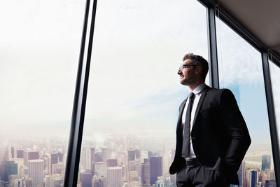 Man looking at city through window