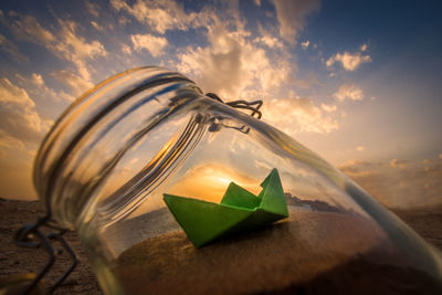 Close-up of paper painting on beach during sunset