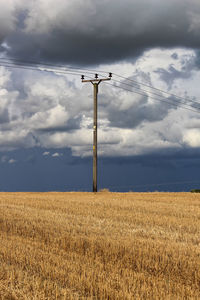 Wind turbines on field against sky