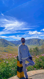 Man standing on mountain against blue sky