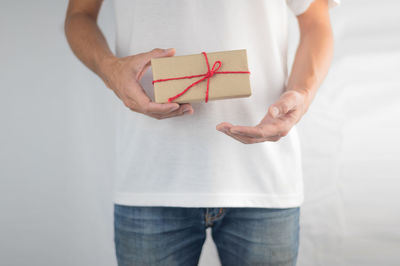 Midsection of woman holding paper while standing in box