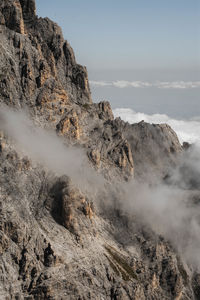 Scenic view of rocky mountains in foggy weather