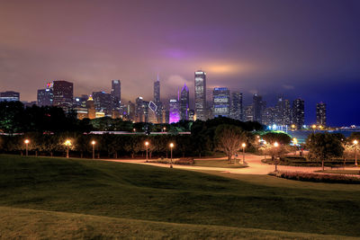 Illuminated buildings in city against sky at night