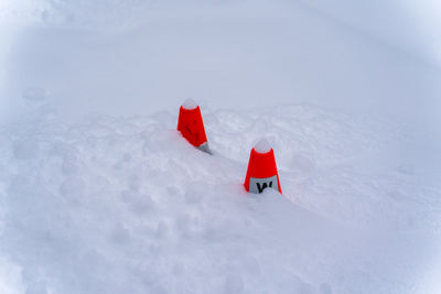 Red umbrella on snow covered land