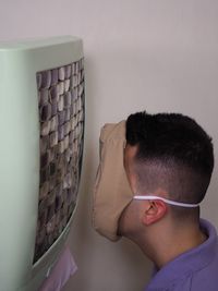 Close-up portrait of young man against wall