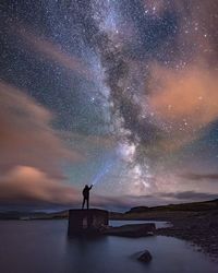 Man standing under star field