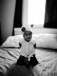 Portrait of girl kneeling on bed at home