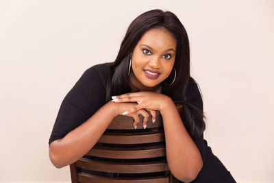 Portrait of smiling young woman against white background