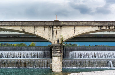 Arch bridge over river against sky