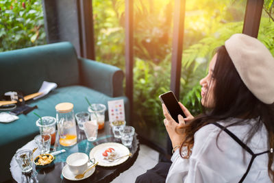 Female friends using mobile phone while sitting at home